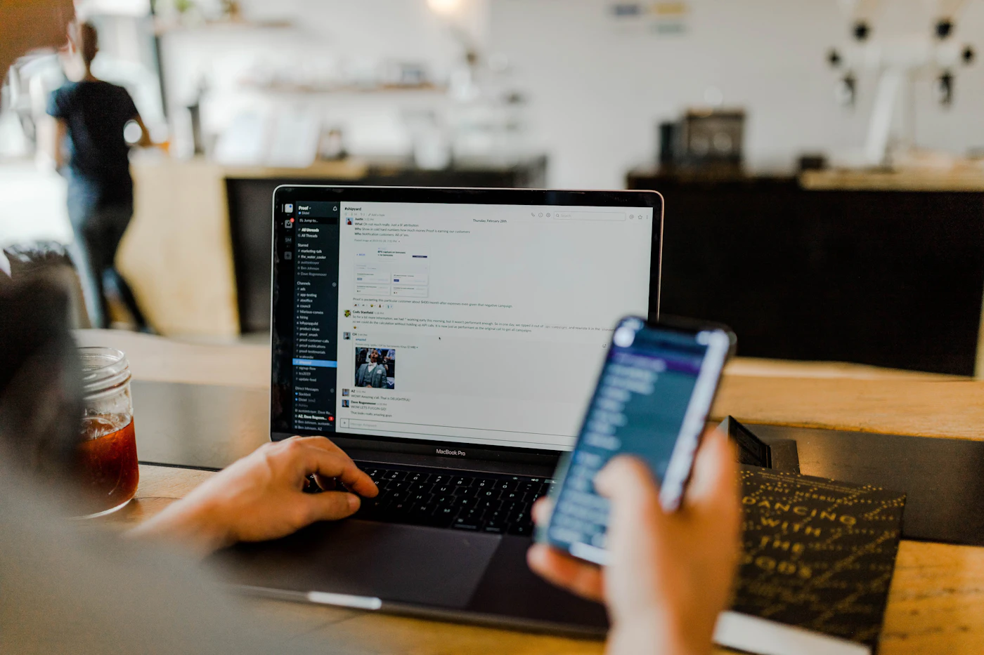 Person using a mobile app alongside a laptop