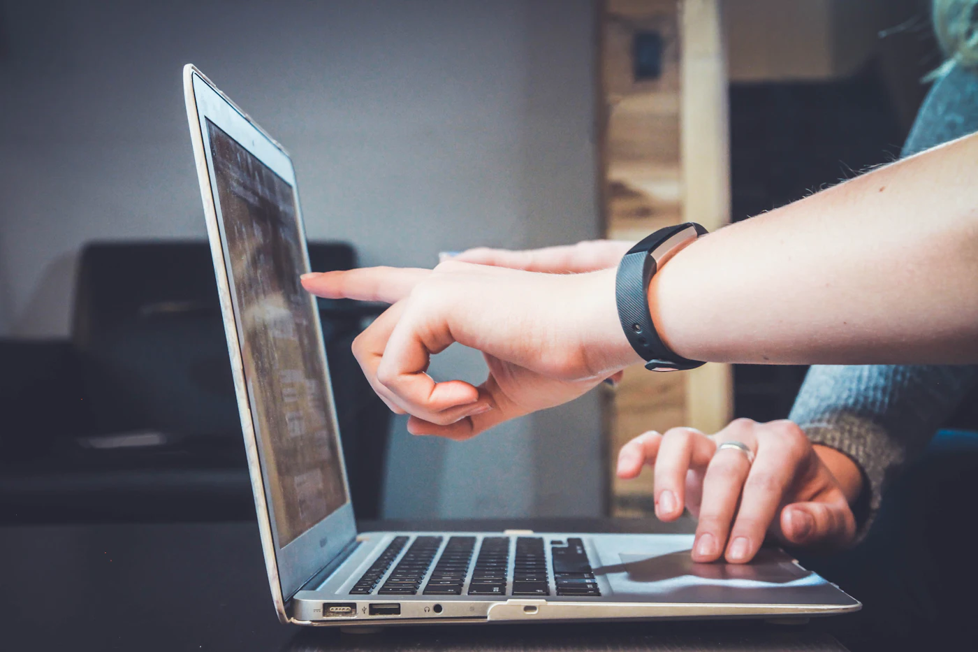 Two colleagues reviewing an application on a laptop
